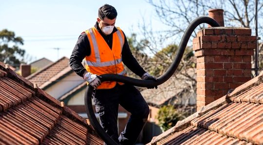 Vacuum hose hauled along a roof ridge