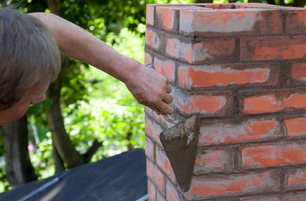 Trowel dressing fresh mortar joints on brick