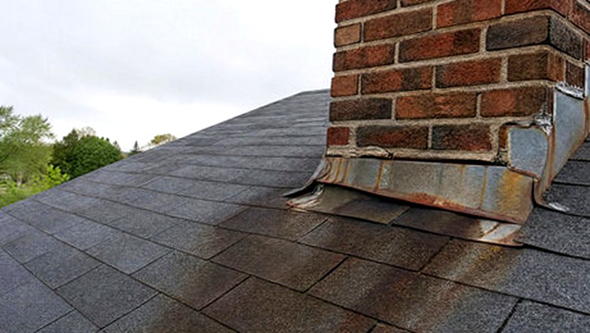 Rust running from failed chimney flashing across the shingles